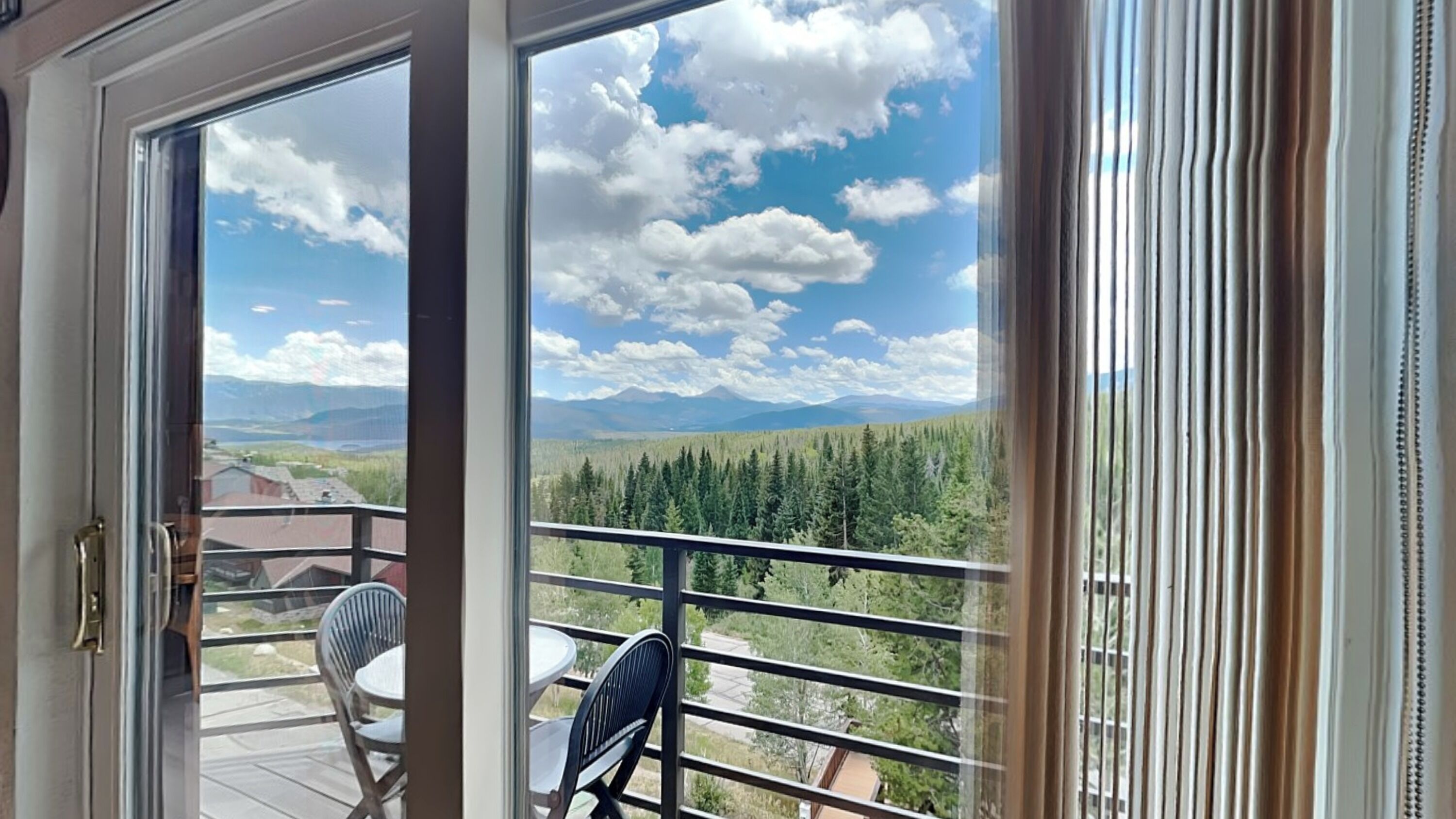 A balcony with a view of a forest and mountains.