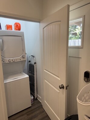 A laundry area with a washer and dryer, a drying rack, and a door leading to an outdoor area. - Yellowhammer | 1.8 Miles to Bryant-Denny Stadium (Tuscaloosa)