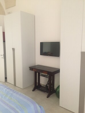A room with a bed, a desk, a television, and a wardrobe. - Cozy, self-contained apartment just a few minutes from the historic center of Lecce (Lecce)