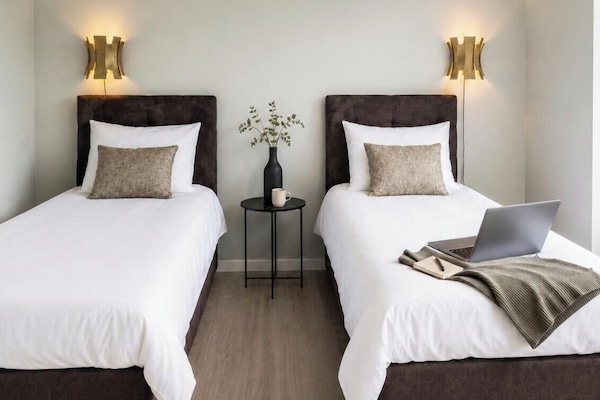 Flexible box-spring beds arranged as two singles, with a shared table and laptop-friendly space