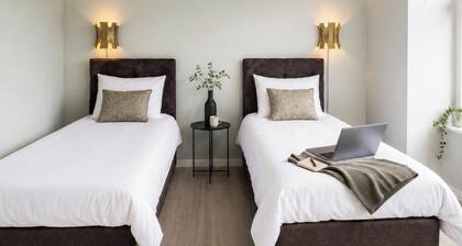 Bright private room with a flexible box-spring bed, private bathroom, shared fully equipped kitchen and a cozy seating area for coffee, a light breakfast or laptop work. Ideal for business travelers, solo guests, couples.