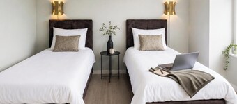 Bright private room with a flexible box-spring bed, private bathroom, shared fully equipped kitchen and a cozy seating area for coffee, a light breakfast or laptop work. Ideal for business travelers, solo guests, couples.