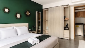 Een hotelkamer met een bed, een kledingkast en een bureau.