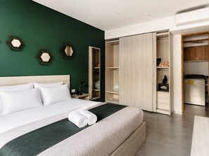 A hotel room with a bed, a wardrobe, and a desk. - One Bedroom Apartment (Playa Del Carmen)