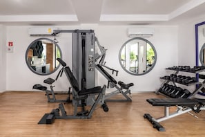 A gym with exercise equipment, mirrors, and a rack of dumbbells. - One Bedroom Apartment (Playa Del Carmen)