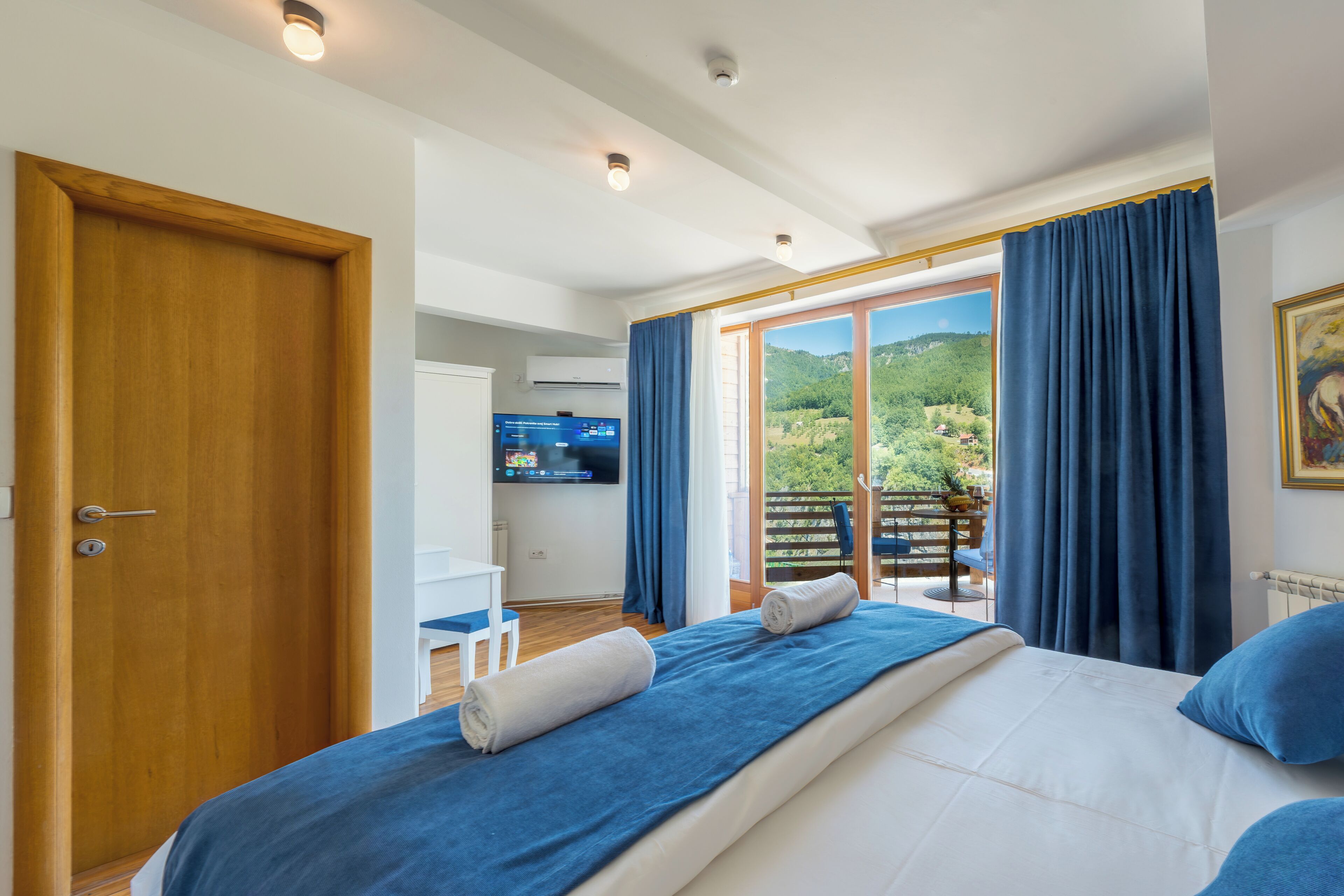 Un dormitorio con cama, televisión y vistas al exterior.