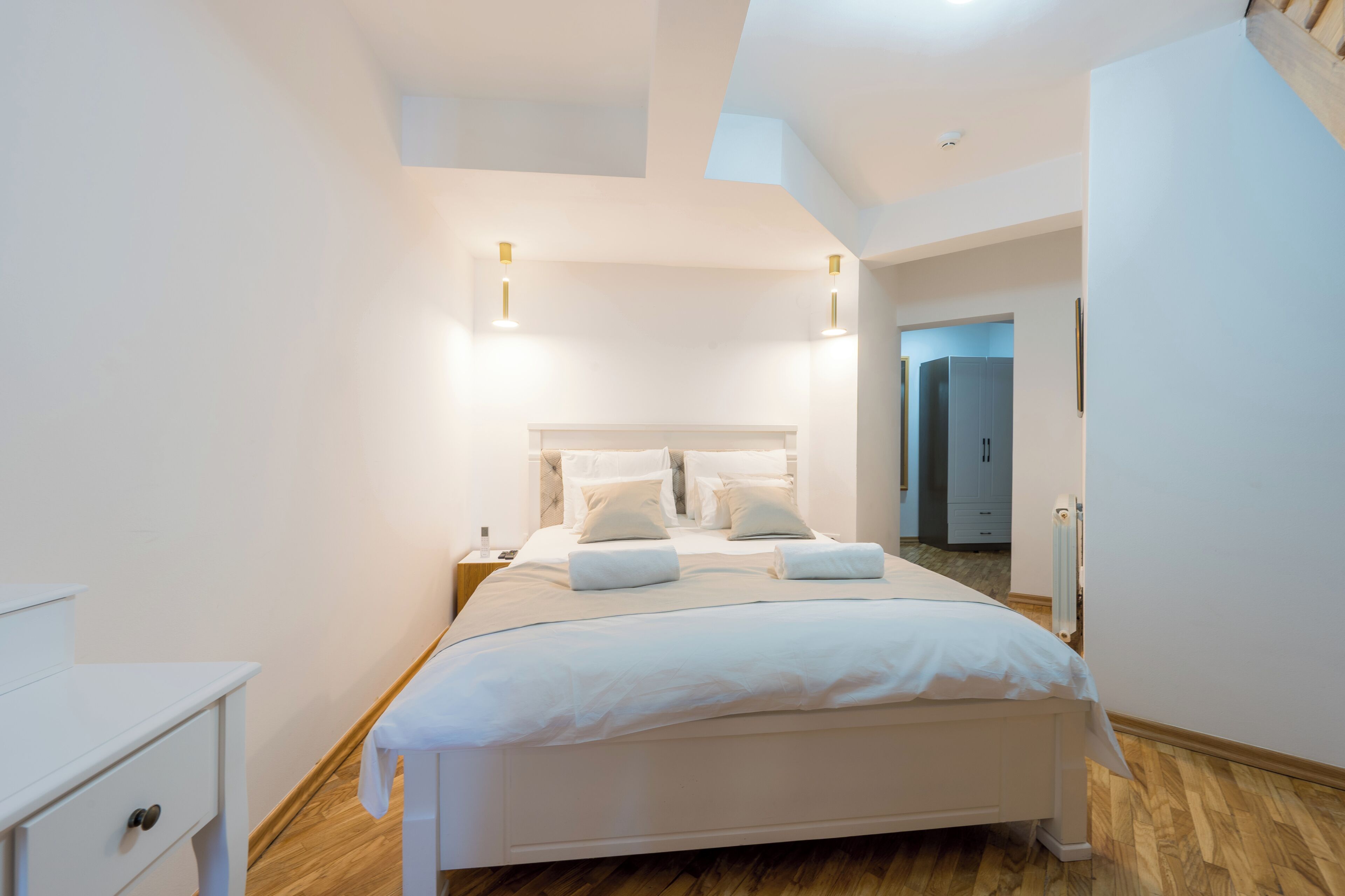 Un dormitorio moderno con cama, mesitas de noche y un armario.