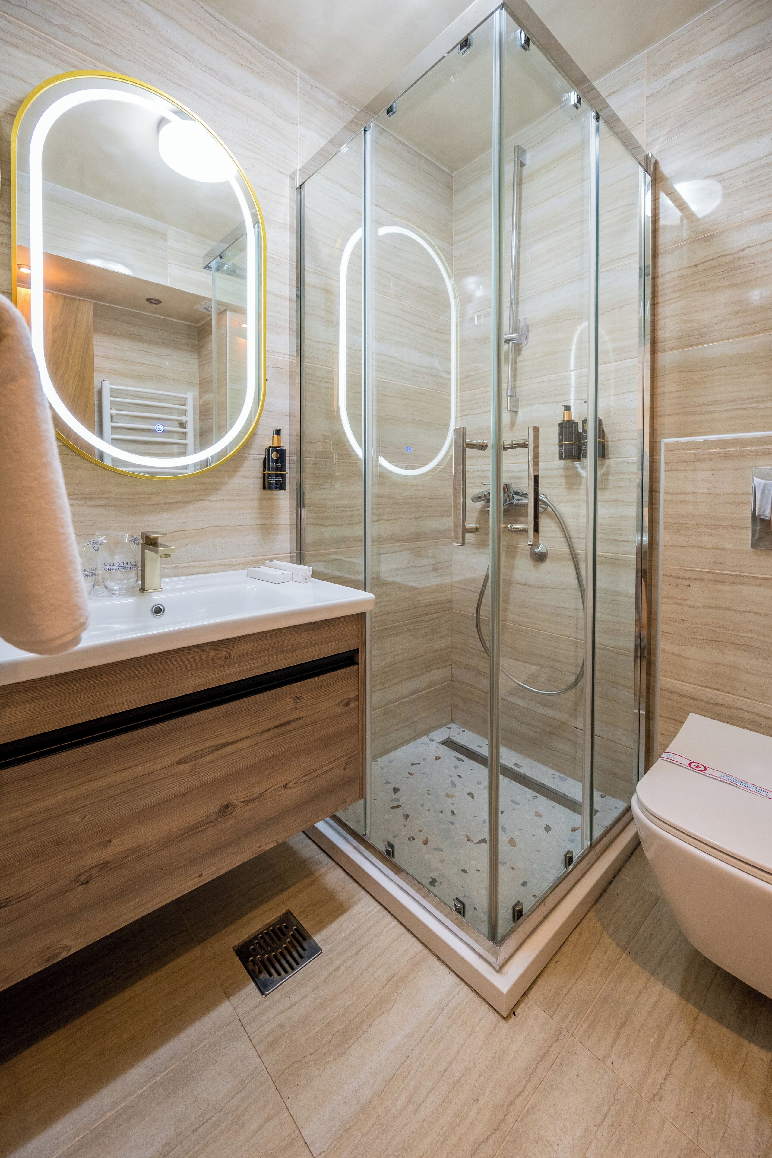 A modern bathroom with a glass-enclosed shower, a vanity with a mirror, and a toilet.