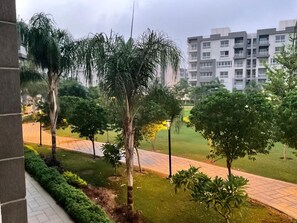 A residential area with a paved walkway, green lawns, and trees. - Terrific 3-bedroom apartment with AC and Free-Wifi in lovely Madinty Garden View (Madinaty)