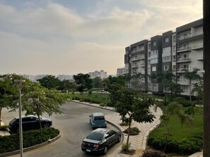 Un quartier résidentiel comprenant un parking, un immeuble à plusieurs étages et des espaces verts.