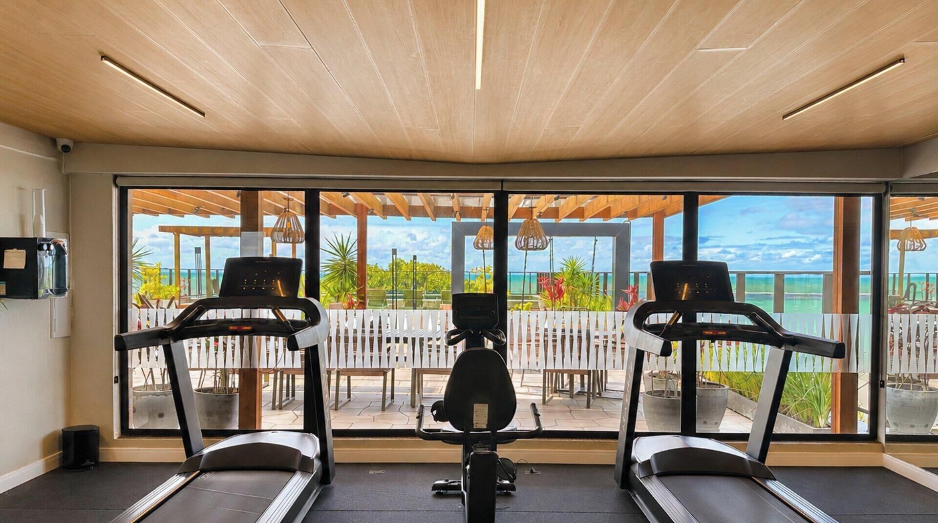 Ein Fitnessraum mit Laufbändern und Blick ins Freie.