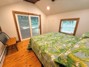 Une chambre à coucher avec un lit, une chaise, une fenêtre et une porte.