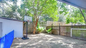 A backyard with a basketball hoop, a wooden fence, and a shed. - 2-unit Combo 10 Mi to Vintage Park & Airport! (Houston)