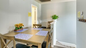 A dining area with a wooden table, chairs, and a potted plant. - 2-unit Combo 10 Mi to Vintage Park & Airport! (Houston)