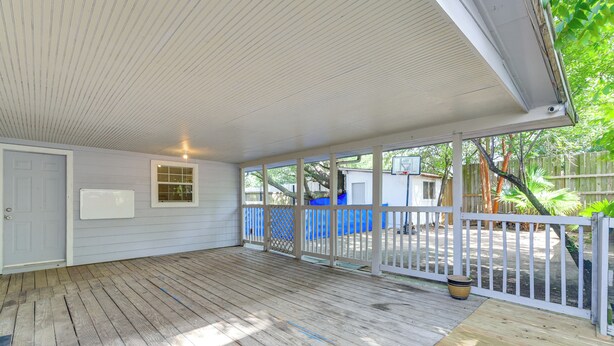 A covered porch with a wooden floor, a white door, and a window. - 2-unit Combo 10 Mi to Vintage Park & Airport! (Houston)