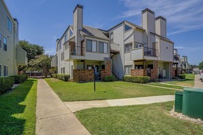 Ein mehrgeschossiges Wohnhaus mit Innenhof, Balkonen und einer Ziegel-Fassade.