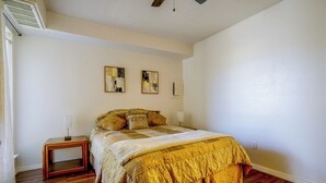 Ein Schlafzimmer mit einem Bett, zwei Nachttischen und Bildern an der Wand.