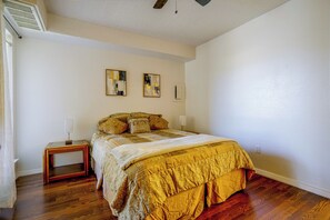 A bedroom with a bed, two bedside tables, and artwork on the wall. - Walk to Shops & Museums! Fort Worth Condo w/ Pool (Fort Worth)