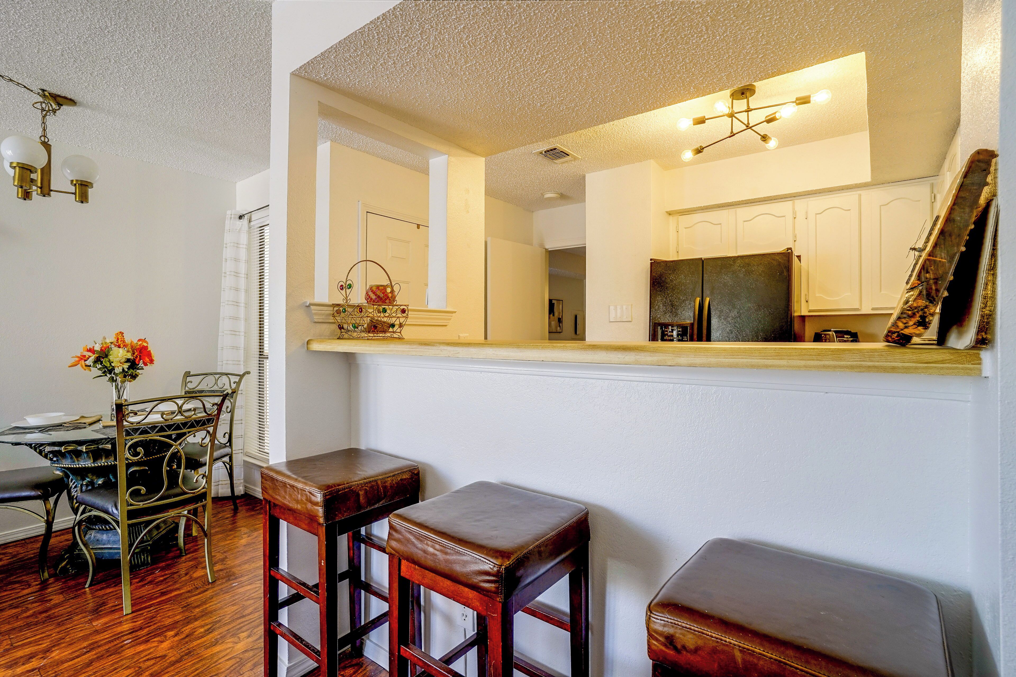 A dining area with a table, chairs, and a vase of flowers.