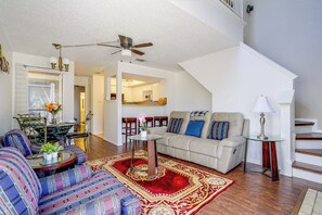 Ein geräumiges Wohnzimmer mit Sofa, Essbereich und Treppe.