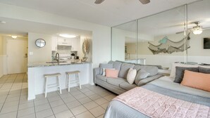 A modern living space with a kitchenette, a dining area, and a bedroom with a large bed and a sofa. - Unwind Poolside, Walk to Shore! Orange Beach Condo (Orange Beach)