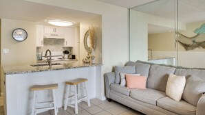 A modern kitchen with a built-in stove, white cabinets, and a granite countertop. - Unwind Poolside, Walk to Shore! Orange Beach Condo (Orange Beach)