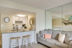 A modern kitchen with a built-in stove, white cabinets, and a granite countertop. - Unwind Poolside, Walk to Shore! Orange Beach Condo (Orange Beach)