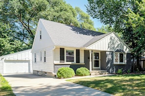 A single-story house with a garage, a covered porch, and a well-maintained lawn.
