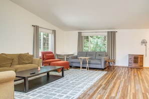 A living room with a sofa, armchair, coffee table, and a small side table. - Wooded Retreat 2 Mi to Kitsap Memorial State Park! (Poulsbo)