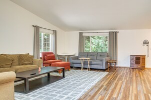 Una sala de estar con sofá, sillón, mesa de centro y una mesita auxiliar.
