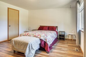 A bedroom with a bed, a bedside table, a chair, and a wardrobe.