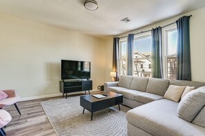 A modern living room with a flat-screen TV, a sofa, a coffee table, and a patterned rug. - Spacious Newark Duplex w/ 2 Levels & 2 Kitchens! (Newark)