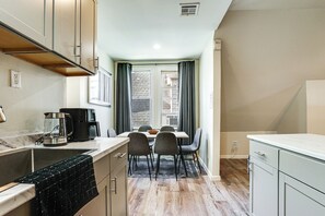 A compact kitchen with a dining area, a coffee maker, and a view of the outside. - Spacious Newark Duplex w/ 2 Levels & 2 Kitchens! (Newark)
