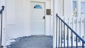 A white door with a window, a mailbox, and a metal gate. - Updated Duplex - 3 Mi to Newark Penn Station! (Newark)