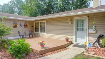 A residential building with a covered patio, outdoor seating, and a garden area.