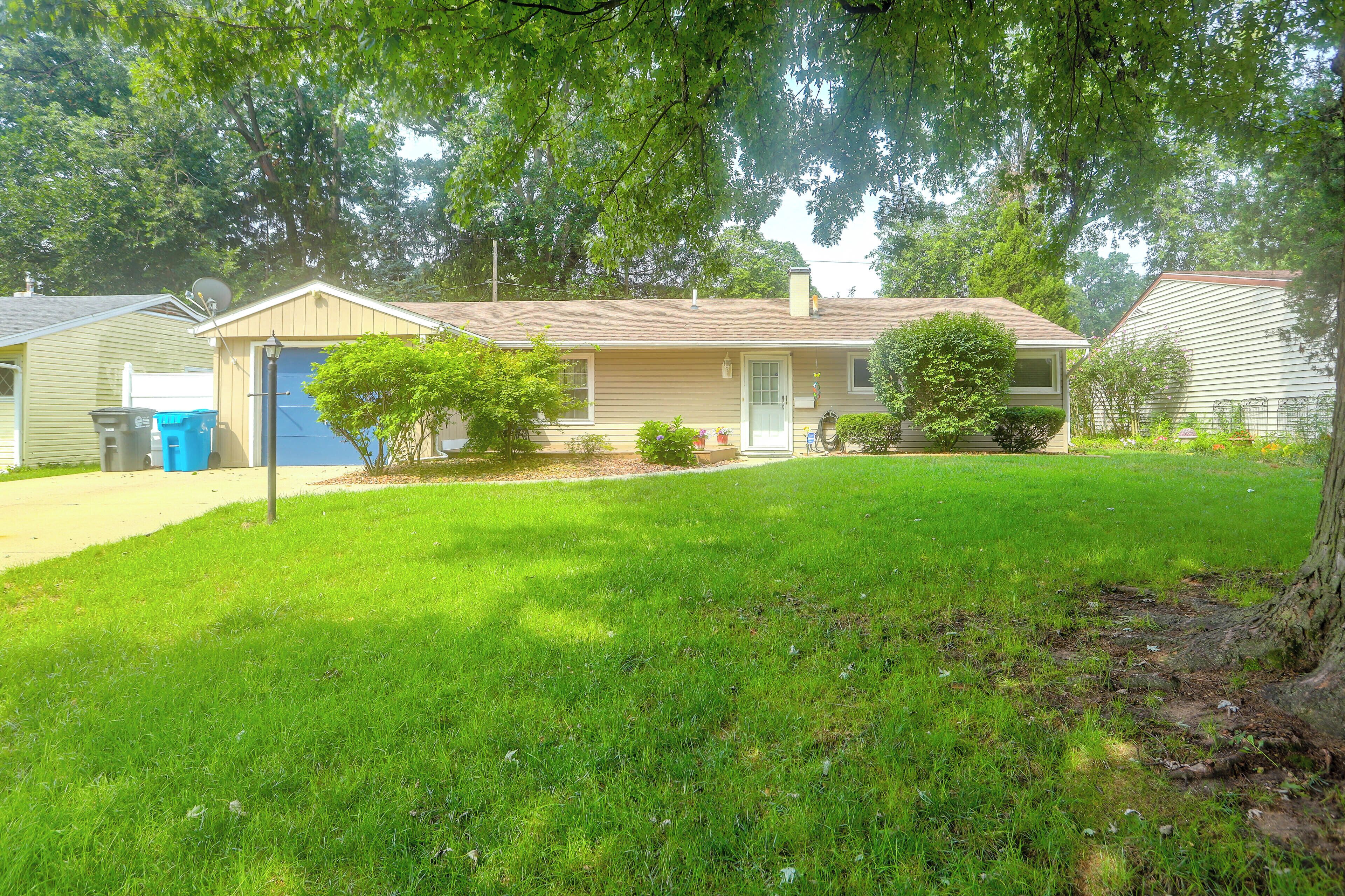 A residential house with a front yard, a garage, and a satellite dish.