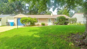 A residential house with a front yard, a garage, and a satellite dish.