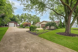 A residential area with a driveway leading to a house with a stone facade. - Stone Manor-luxury Catawba Island Home w/ Hot Tub (Port Clinton)