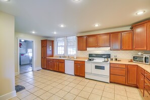A kitchen with wooden cabinets, a stove, a microwave, and a dishwasher.