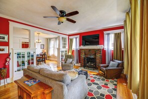 A living room with a fireplace, a ceiling fan, and a patterned rug. - Bristol House & Studio Near State Street (Bristol)