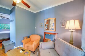 A living room with a sofa, armchair, coffee table, and a lamp.