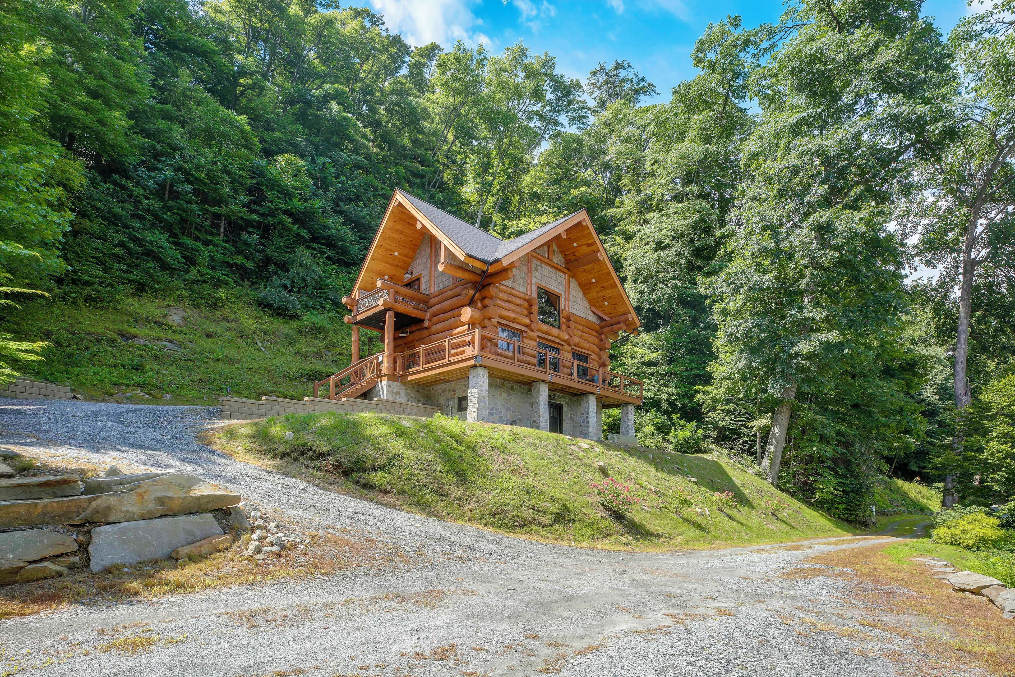 A log cabin with a stone foundation, wooden exterior, and a balcony.