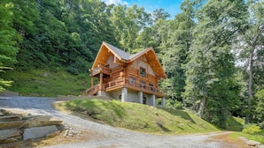 Eine Blockhütte mit Steinfundament, Holzfassade und einem Balkon.