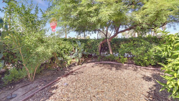 A garden with a gravel path, a stop sign, and various plants. - Soaking Tub, Fire Pit! Hemet Studio Suite (Hemet)