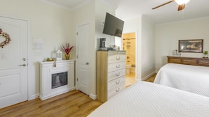 Un dormitorio con cama, cómoda, televisor y ventilador de techo.