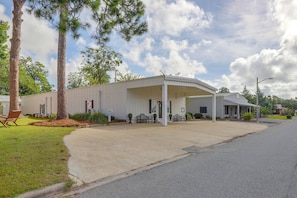 A single-story building with a covered porch, a small front yard, and a clear sky.