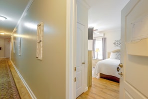 Habitación de hotel con cama, mesita de noche, lámpara y ventana con cortinas.