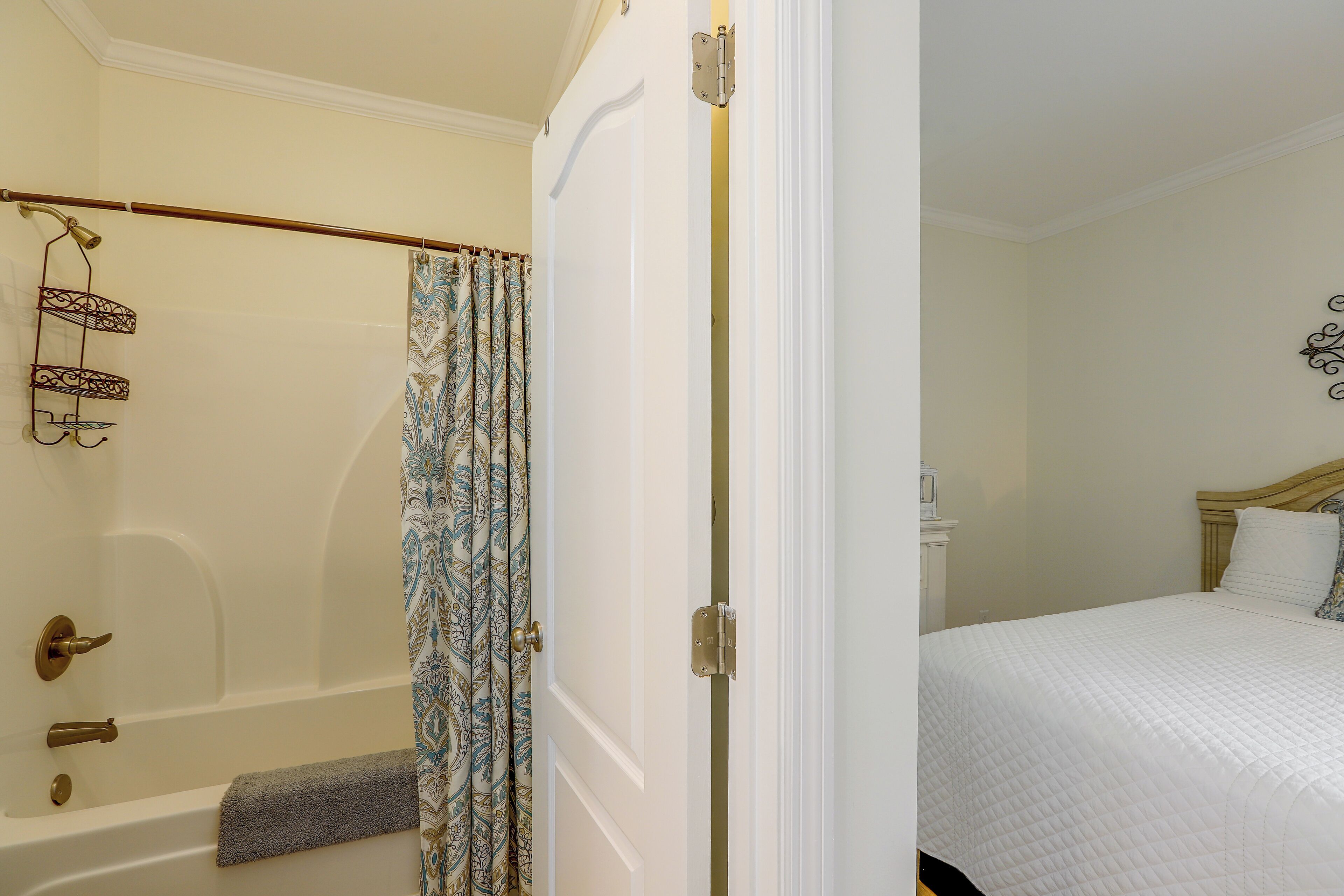 A bathroom with a bathtub, a shower curtain, and a towel rack.