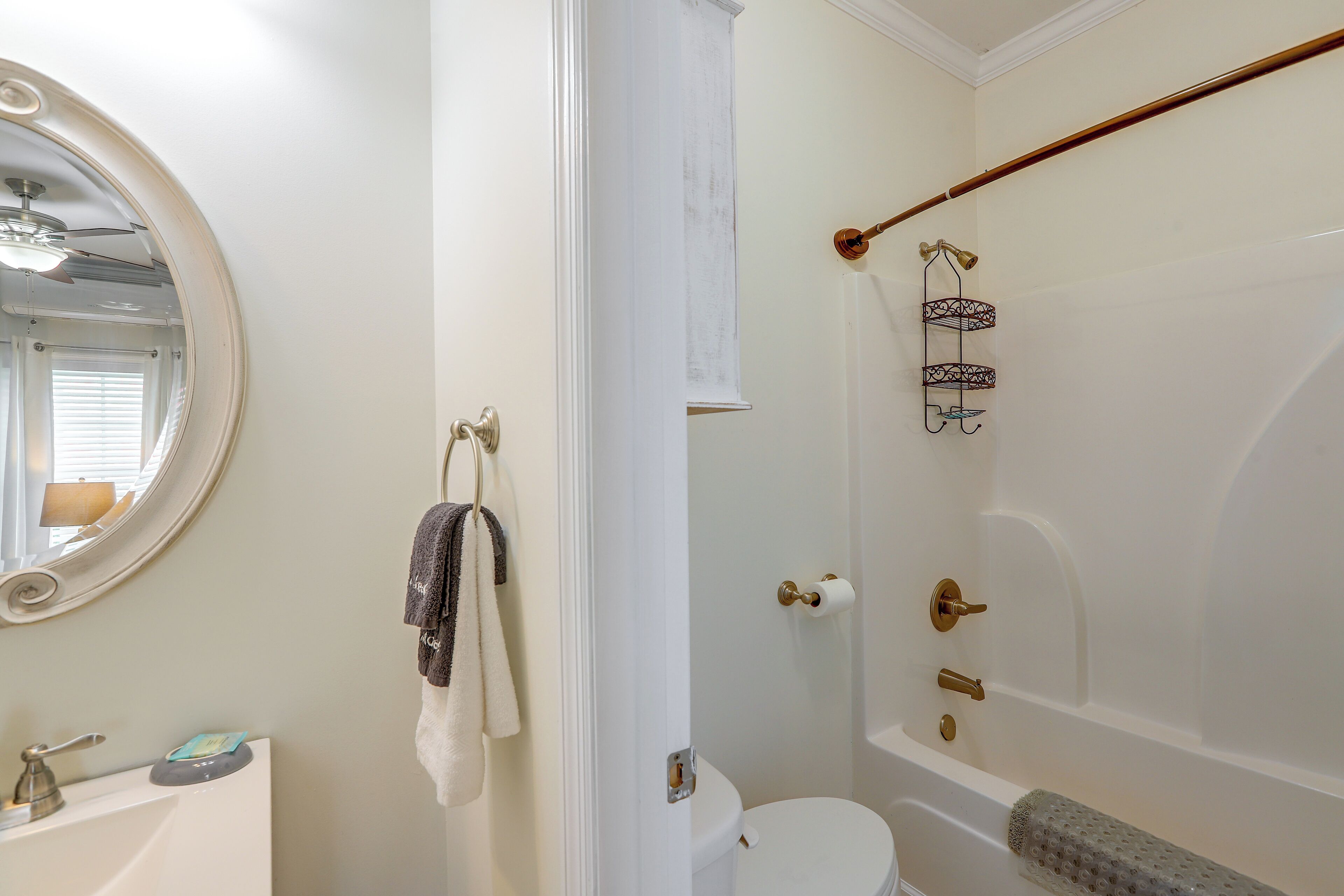 A bathroom with a toilet, a bidet, a towel rack, a mirror, and a shower area.