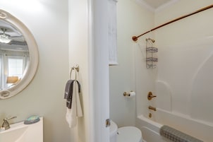 A bathroom with a toilet, a bidet, a towel rack, a mirror, and a shower area.